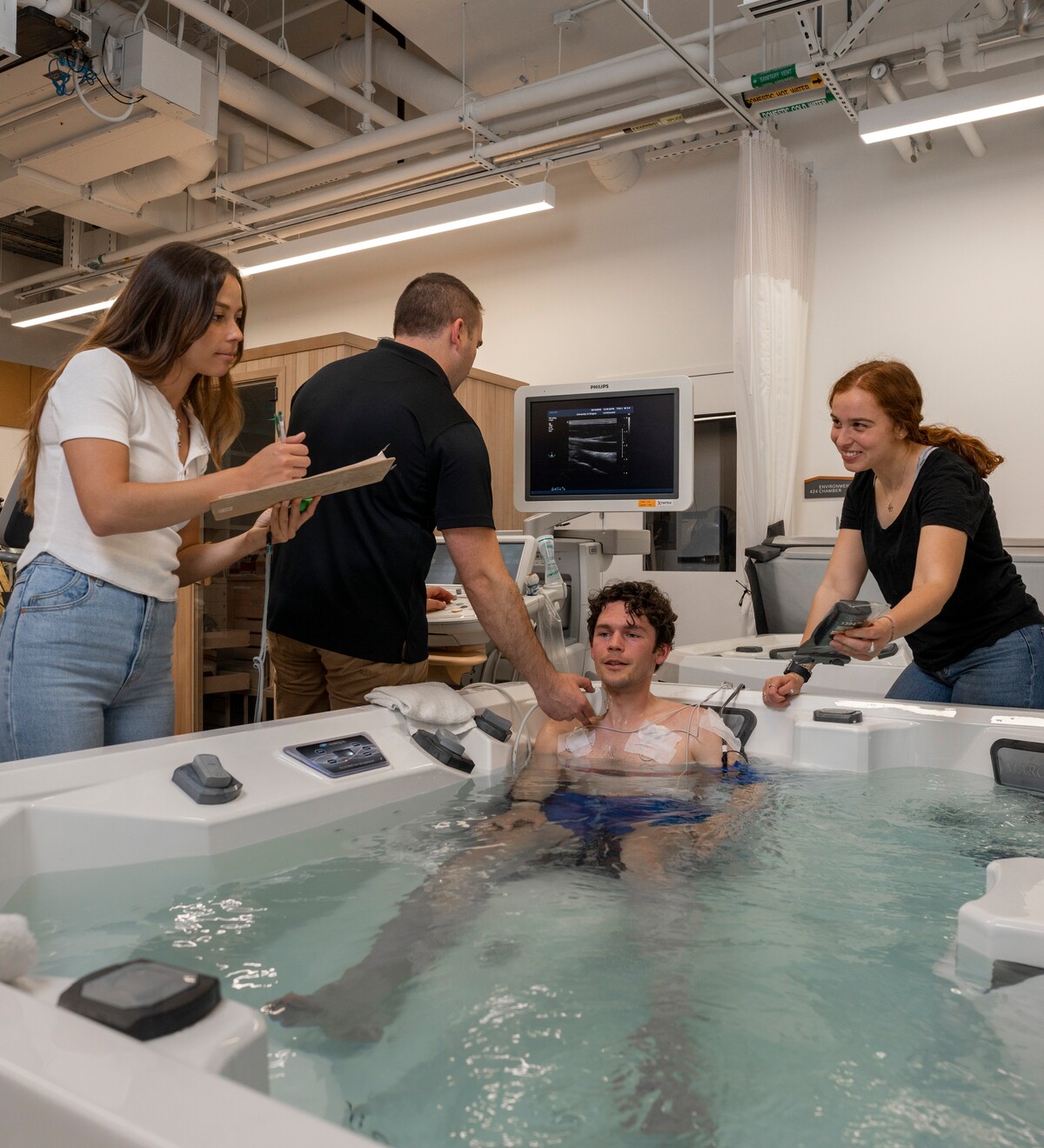 Researchers monitor a participant during aquatic exercise testing.