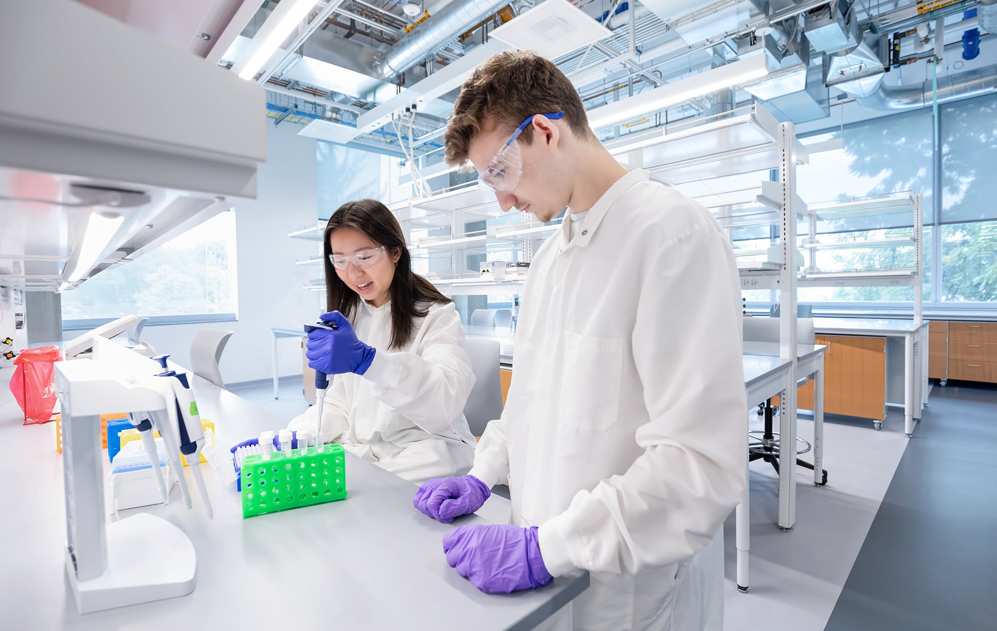 Two researchers pipette samples in a Knight Campus laboratory.