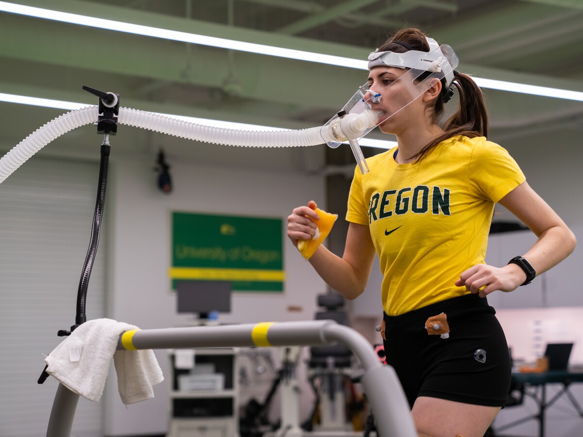 A runner completes a treadmill test while wearing breathing equipment.