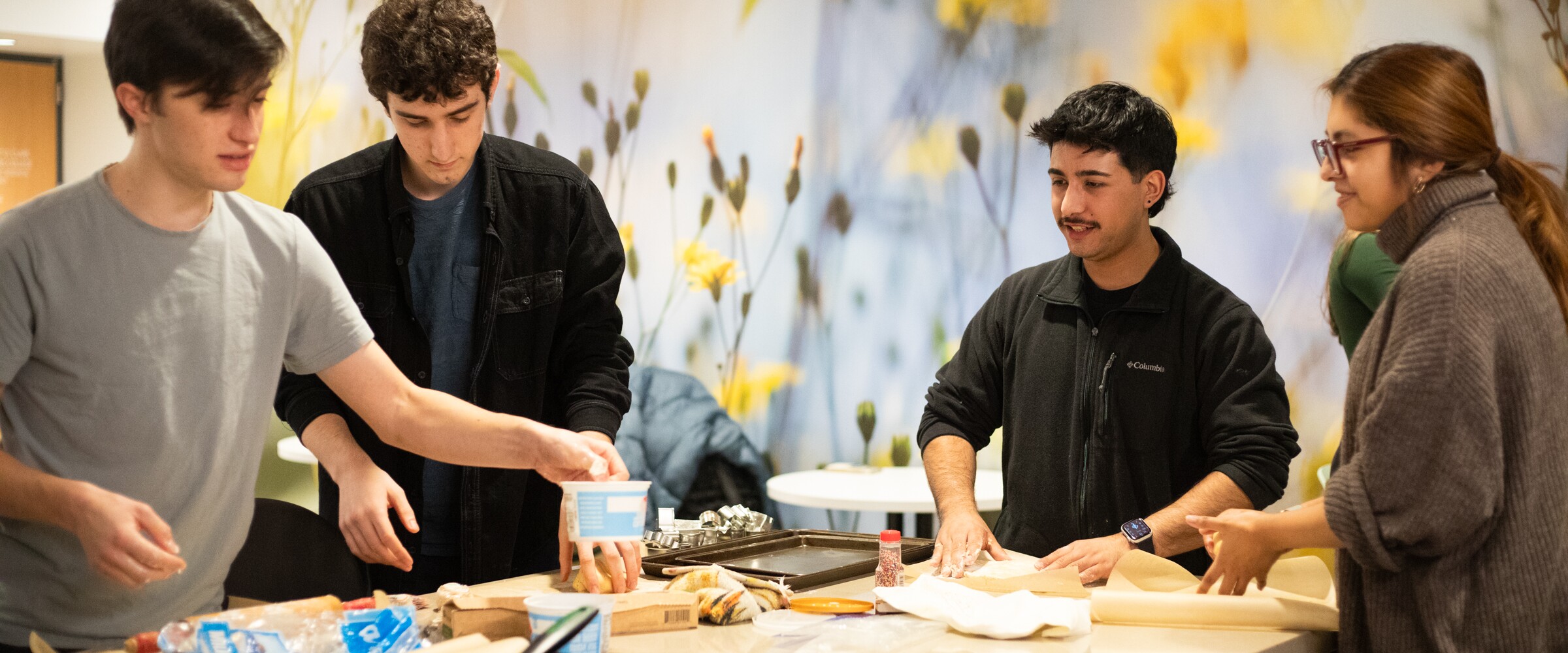 Students prepare food together in a shared kitchen.