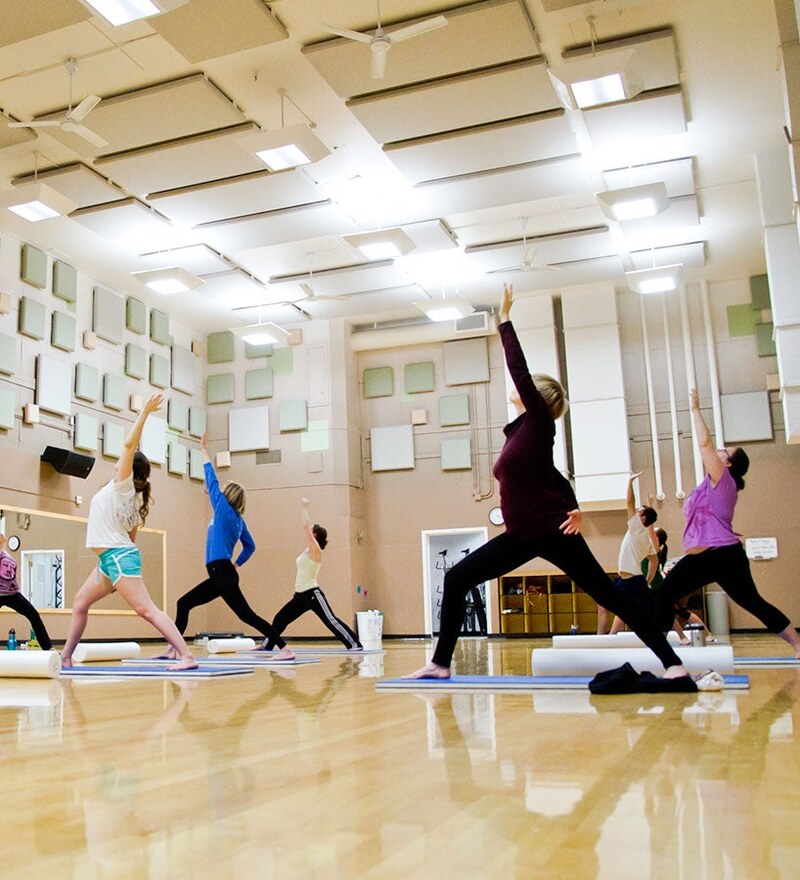 Students practice yoga together in a fitness studio.