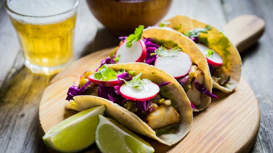 Tacos are served with lime wedges.