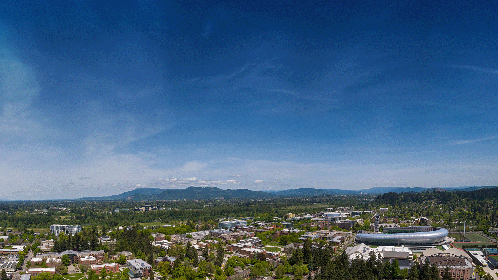 Aerial view of Eugene and the University of Oregon campus under a blue sky.