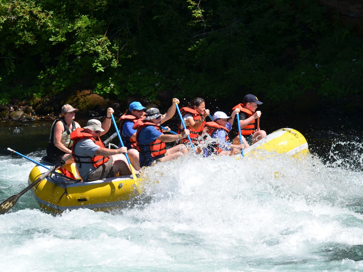 Students paddle a raft through whitewater.